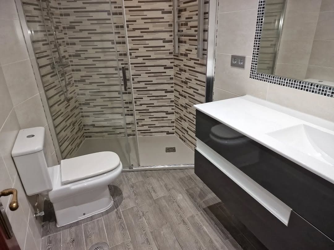 Baño reformado con grifería empotrada y azulejos claros
